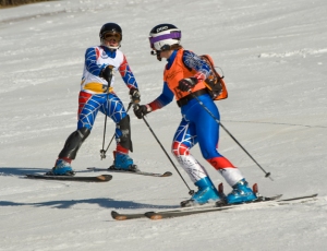 100% blind athlete Lindsay Ball being guided through the icy slalom course by Dianne Barris 